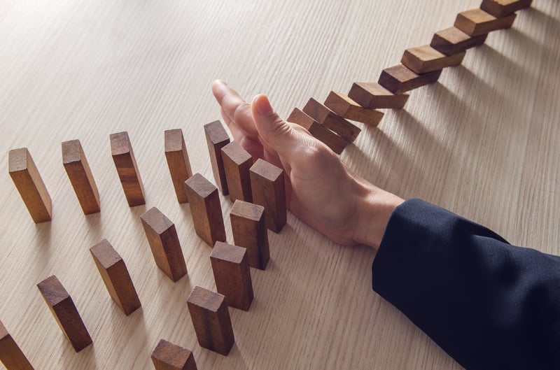 A hand whiping away a set of domino pieces